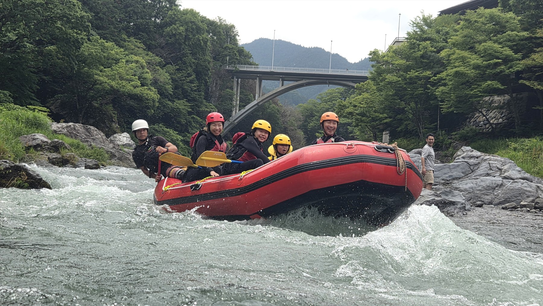 Family guests rafting on the Tama River near Tokyo with mountain scenery